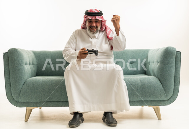 رجل سعودي يلعب ألعاب الفيديو ويحتفل على الأريكة
