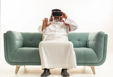 رجل سعودي مسن يرتدي ملابس تقليدية ويستخدم نظارة الواقع الافتراضي