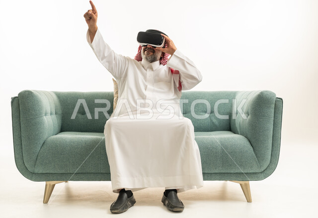 رجل سعودي يستخدم نظارة الواقع الافتراضي على الأريكة