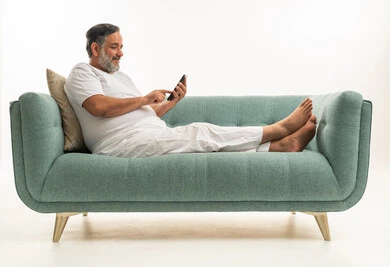 Saudi Man Relaxing on Sofa Using Smartphone
