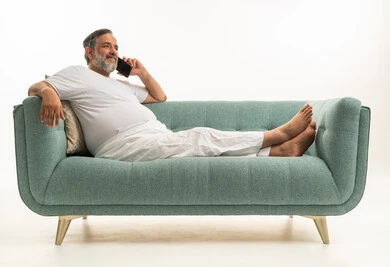Saudi Man Relaxing on Sofa Using Smartphone