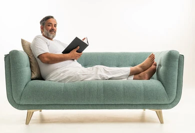 Indian Man Reading Book on Modern Green Studio Sofa