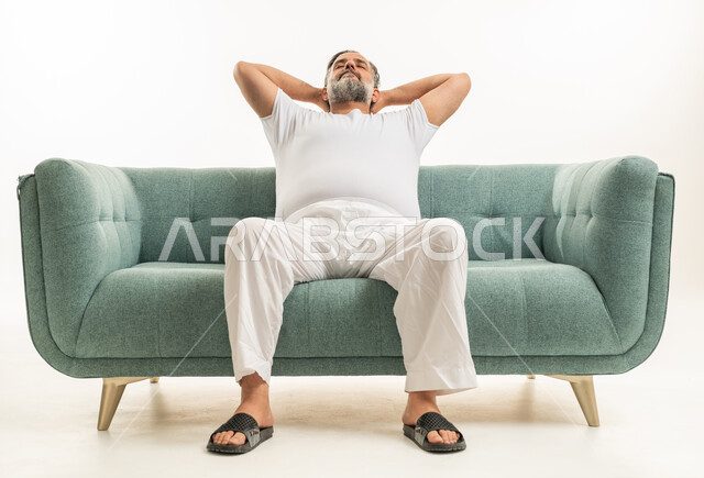 رجل عربي في منتصف العمر يسترخي على أريكة