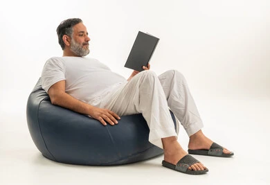 Middle-Aged Arab Man Reading Book on Blue Bean Bag