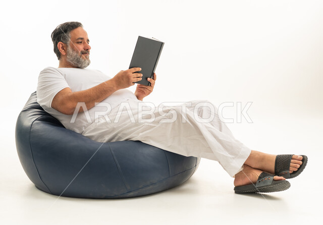 رجل عربي يقرأ كتاباً جالساً على بين باج