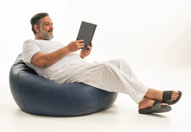 Arab Man Reading a Book on Blue Bean Bag