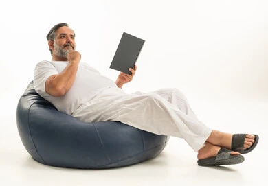 Middle-aged Saudi Man Reading on Blue Beanbag