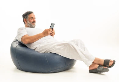 Saudi Man Relaxing on Bean Bag Using Smartphone