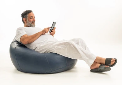رجل سعودي يجلس على بين باج يستخدم الجوال