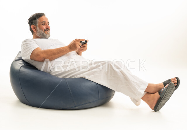 رجل سعودي يلعب ألعاب الفيديو على مقعد استرخاء