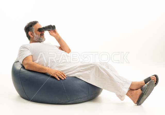 رجل سعودي يستخدم المنظار على مقعد مريح