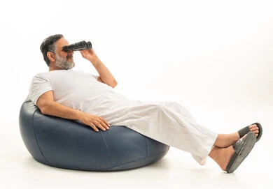 Saudi Man Using Binoculars on Blue Bean Bag