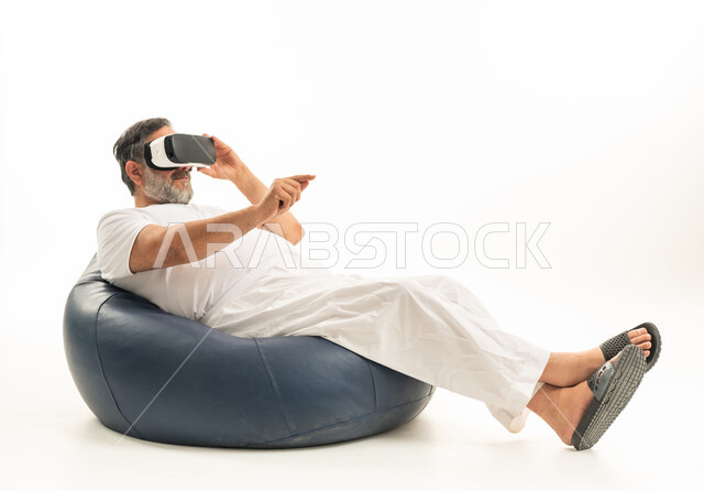 رجل سعودي بالثوب الأبيض يستخدم نظارة الواقع الافتراضي