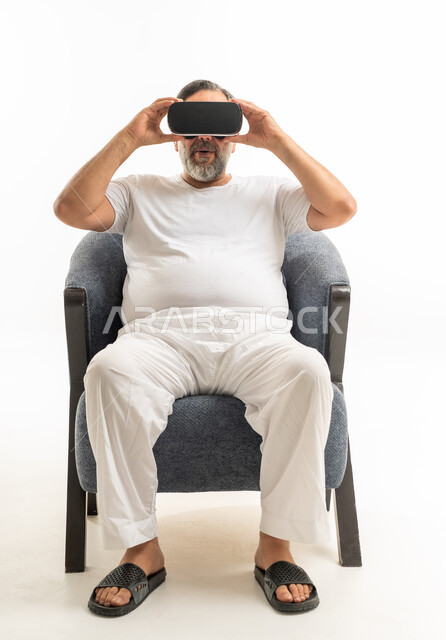 رجل سعودي بملابس منزلية يستخدم نظارة الواقع الافتراضي