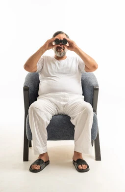 Arab Man with Binoculars Sitting in Armchair Studio
