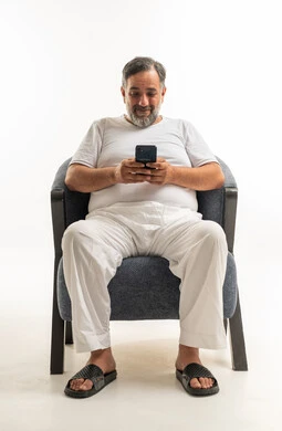 Saudi Man Sitting in Armchair Using Smartphone