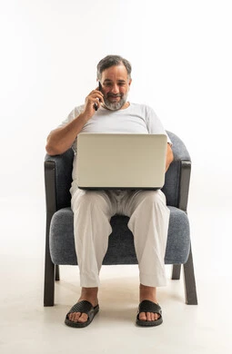 Saudi Man with Laptop and Smartphone in Armchair