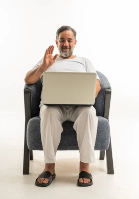 Saudi Man on Laptop Video Call in Armchair