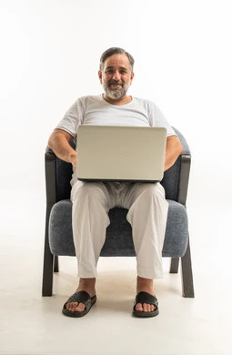 Middle Aged Arab Man Using Laptop in White Loungewear