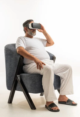 Elderly Arab Man Using VR Headset in Armchair