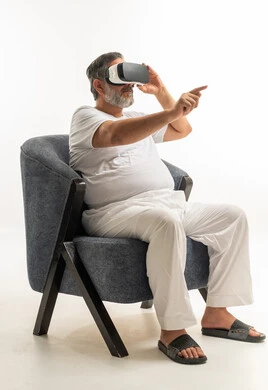 Saudi Senior Wearing VR Headset in Armchair