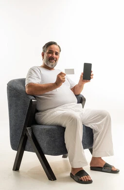 Saudi Man Using Smartphone and Credit Card Seated