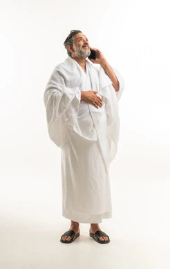 Arab Man in Ihram Talking on Phone on White Background