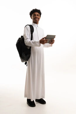 طالب سعودي بالثوب الأبيض يحمل جهاز لوحي رقمي