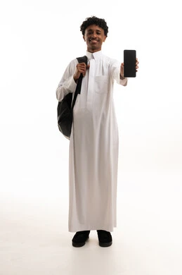 طالب سعودي بالثوب الأبيض يحمل هاتف ذكي وخلفية بيضاء