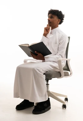 Saudi Man in Thobe Thinking While Reading Book