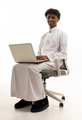 رجل سعودي بالثوب يستخدم لابتوب على خلفية بيضاء رجل سعودي بالثوب يستخدم لابتوب على خلفية بيضاء