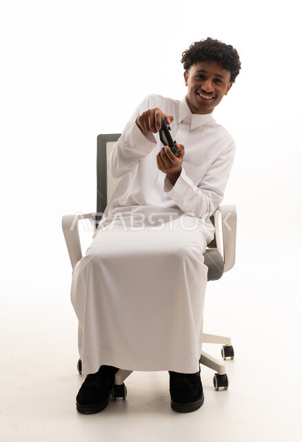 شاب سعودي يلعب ألعاب الفيديو بالثوب التقليدي