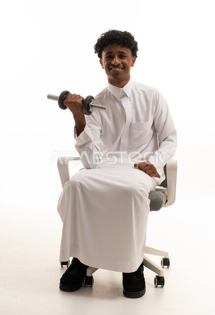 رجل سعودي بالثوب يرفع الأثقال على خلفية بيضاء