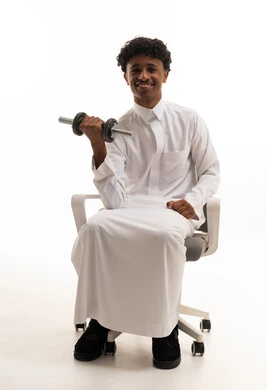 رجل سعودي بالثوب يرفع الأثقال على خلفية بيضاء