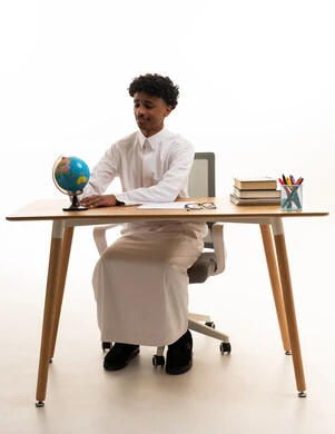 Saudi Student with Globe at Study Desk