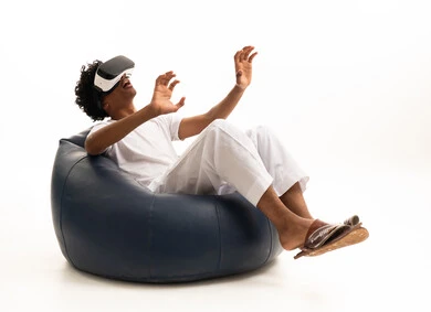 Saudi Man Using VR Headset on Blue Beanbag White Background