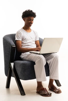 Saudi Young Man Using Laptop in Armchair White Background