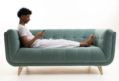 Saudi Man Using Smartphone on Teal Sofa