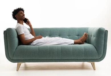 Young Saudi Man Talking on Smartphone on Teal Sofa