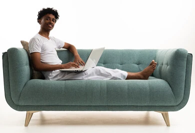 Saudi Young Man Using Laptop on Green Sofa