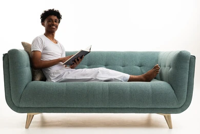 Saudi Man Reading Book on Turquoise Sofa