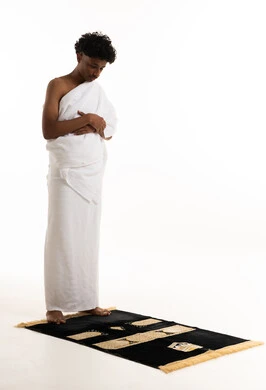 Saudi Man in Ihram Praying on Mat White Background