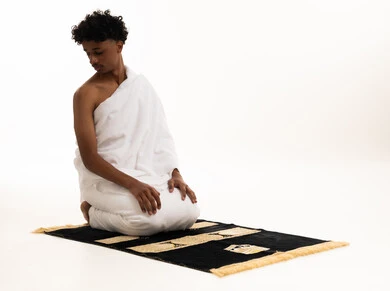Saudi Man in Ihram Sitting on Prayer Mat White Background