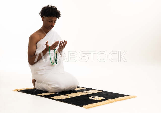 رجل سعودي بملابس الإحرام يدعو بالمسبحة