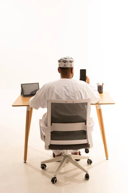 Omani Man at Office Desk with Traditional Clothing