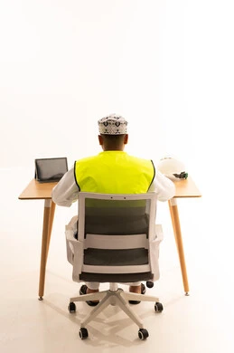 Omani Engineer with Safety Vest at Desk