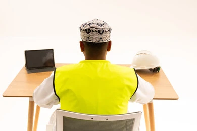 مهندس عماني بزي السلامة على مكتب العمل