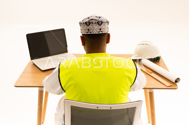 مهندس عماني يعمل على مكتبه من الخلف