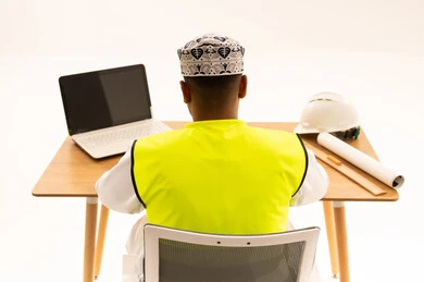 مهندس عماني يعمل على مكتبه من الخلف
