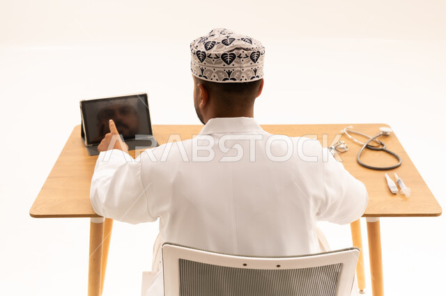 طبيب عماني في عيادته يستخدم جهاز لوحي